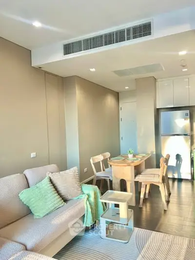 Modern living room with cozy seating and dining area, featuring stylish decor and natural lighting.