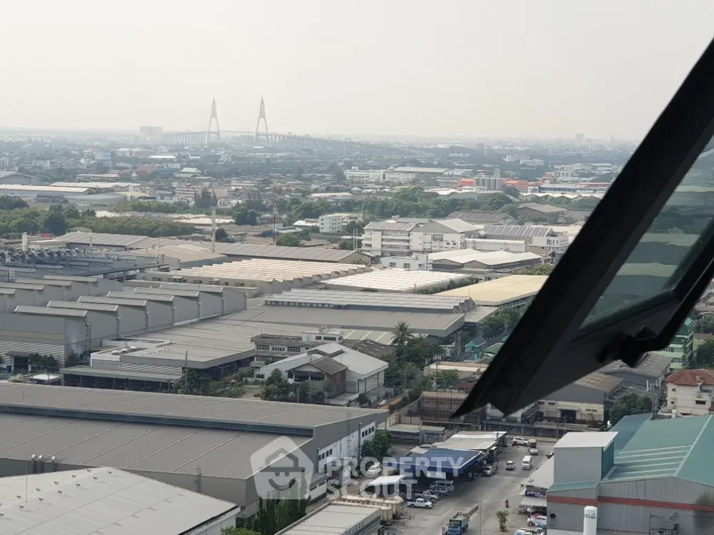 Panoramic cityscape view with industrial buildings and distant bridge