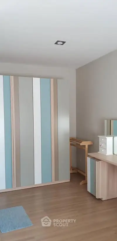 Modern bedroom with stylish wardrobe and wooden flooring