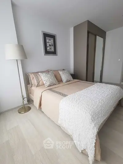 Elegant bedroom with modern decor and cozy bedding in a stylish apartment.