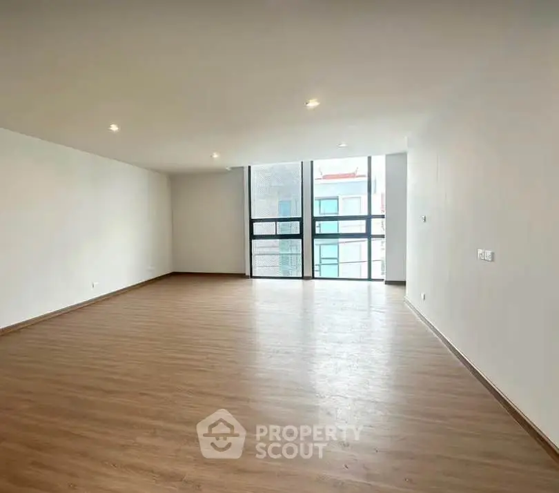 Spacious modern living room with large windows and wooden flooring