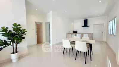 Spacious modern dining area with sleek white furniture and open kitchen layout.