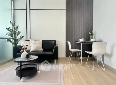 Modern living room with sleek black sofa and minimalist dining area