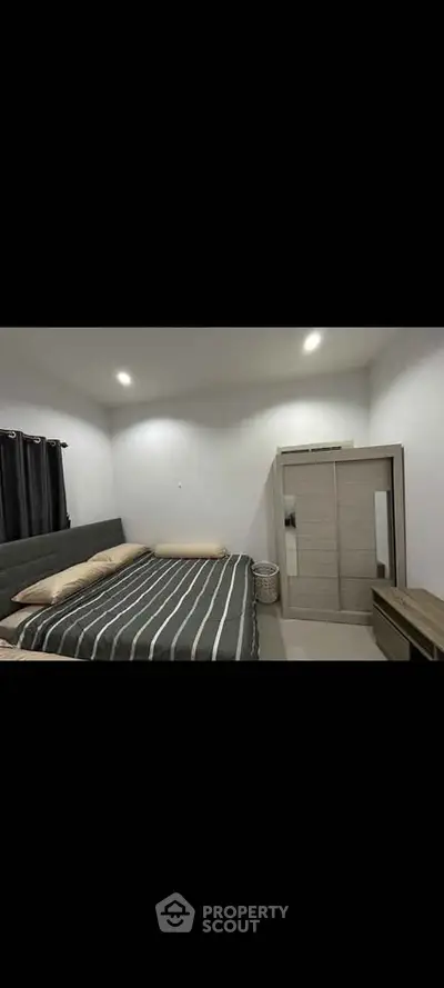 Modern bedroom with striped bedding and sleek wardrobe design