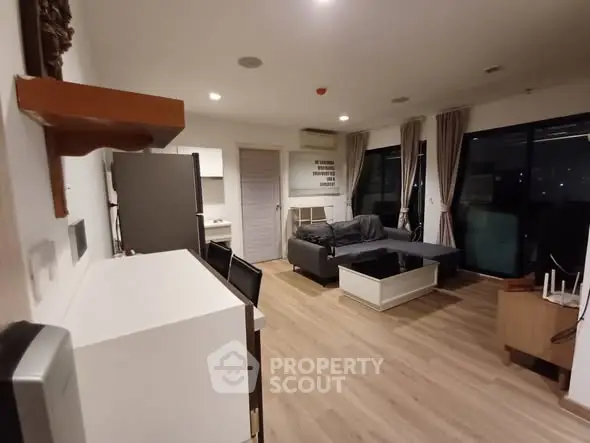 Spacious living room with modern decor and large windows offering city views.