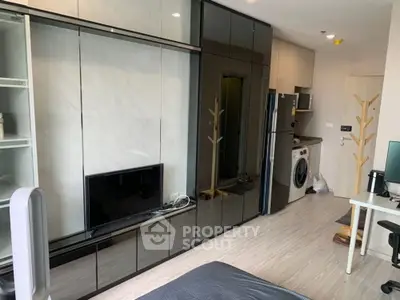 Modern apartment interior with sleek kitchen and living area, featuring built-in appliances and stylish decor.
