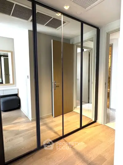 Modern bedroom with mirrored closet doors and wooden flooring