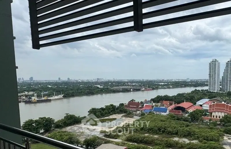 Stunning river view from high-rise balcony overlooking lush greenery and cityscape.