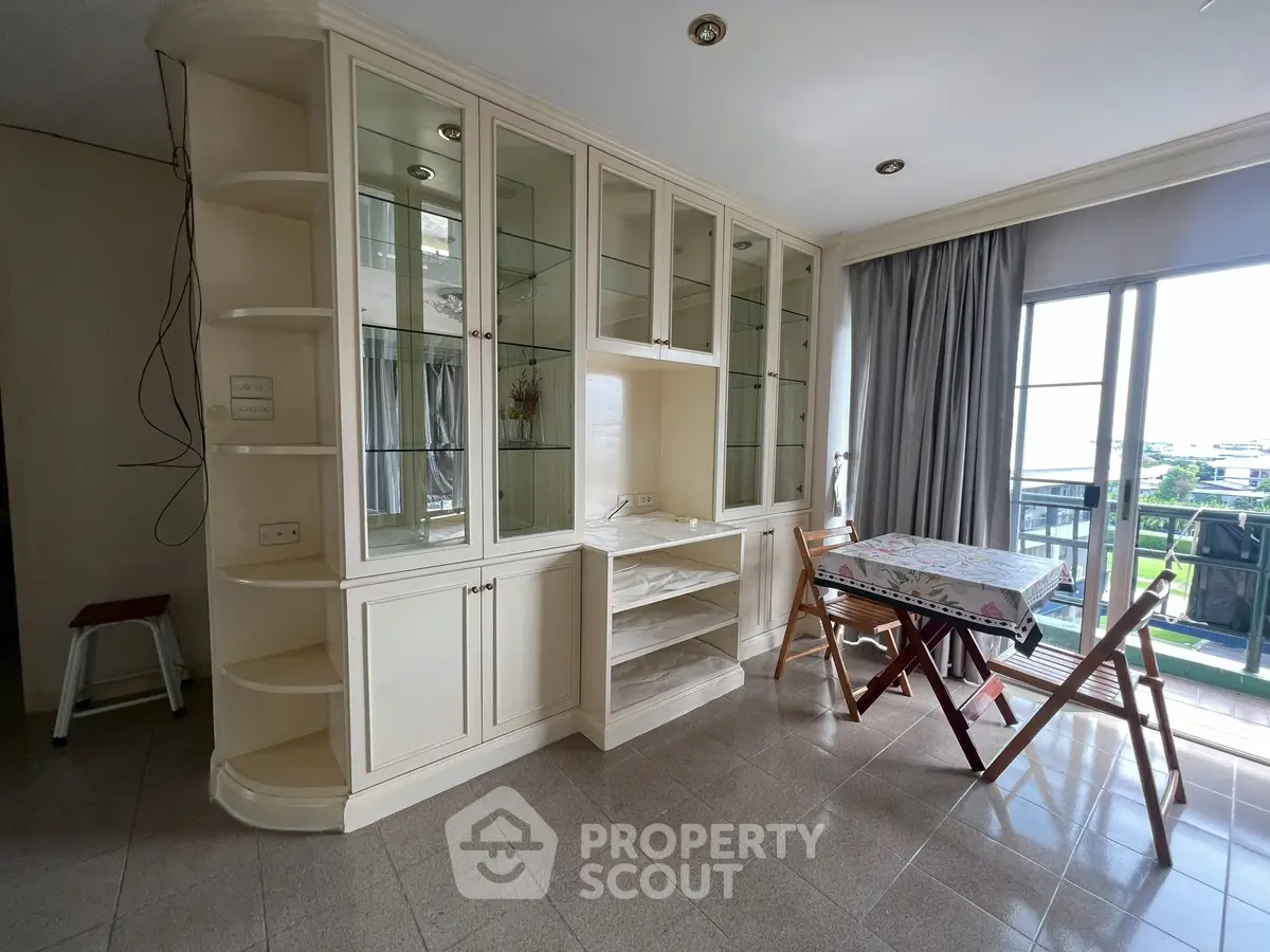 Spacious living area with built-in shelves and balcony view