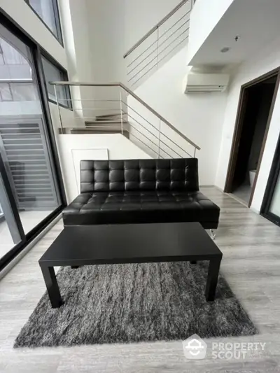 Modern living room with sleek black sofa and coffee table in stylish apartment