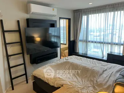 Modern bedroom with wall-mounted TV and large window offering city view.