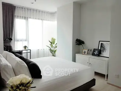 Modern bedroom with large window, stylish decor, and natural light.