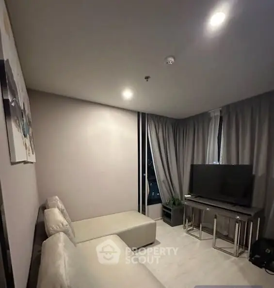 Modern living room with cozy seating and large TV, perfect for relaxation.