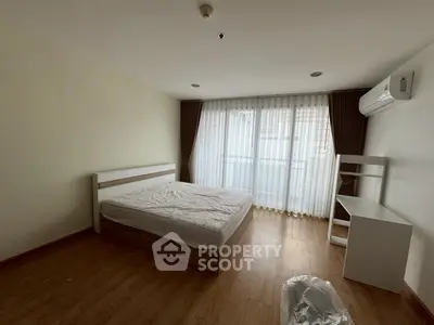 Spacious bedroom with large window and modern furnishings