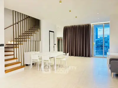 Spacious modern living room with elegant staircase and dining area
