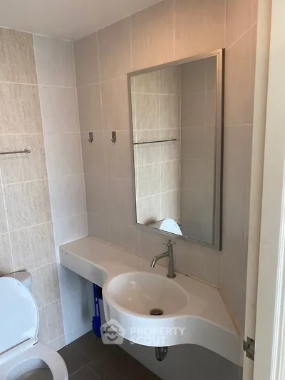 Modern bathroom with sleek sink and mirror in a stylish real estate property.