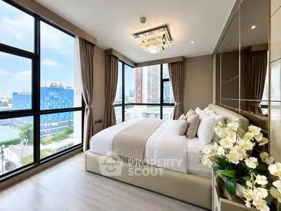 Luxurious bedroom with floor-to-ceiling windows offering stunning city views, elegant decor, and plush bedding.