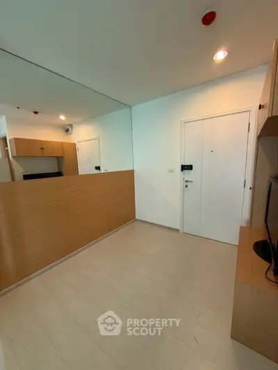 Modern apartment entrance with wood paneling and large mirror