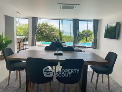 Luxurious open-plan living room with stunning pool and nature view, perfect for modern living.