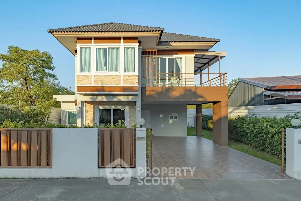 Modern two-story house with spacious driveway and large windows, surrounded by greenery and clear blue sky.