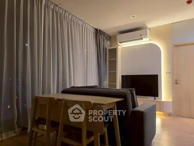 Modern living room with sleek furniture and ambient lighting, featuring a cozy dining area and stylish decor.