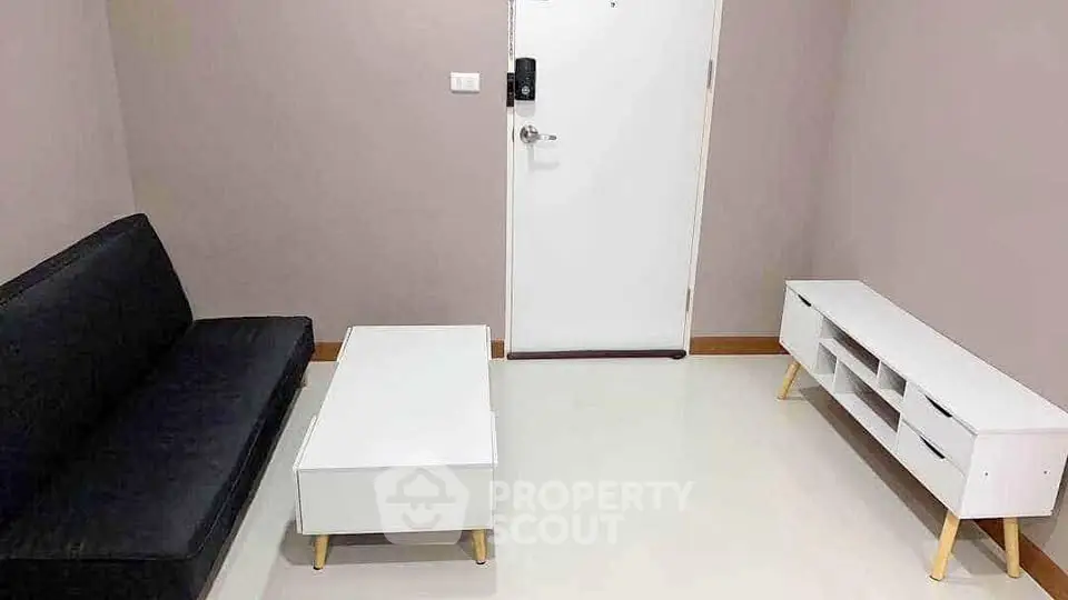 Modern minimalist living room with sleek black sofa and white furniture