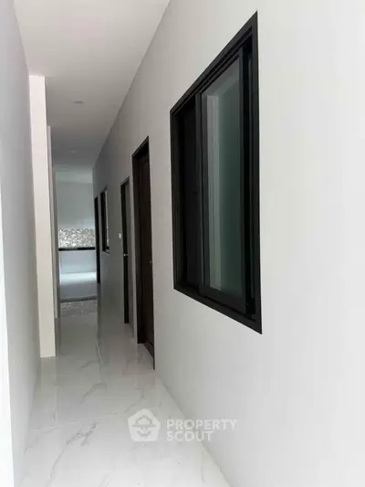 Sleek modern hallway with marble flooring and large windows in a contemporary home.