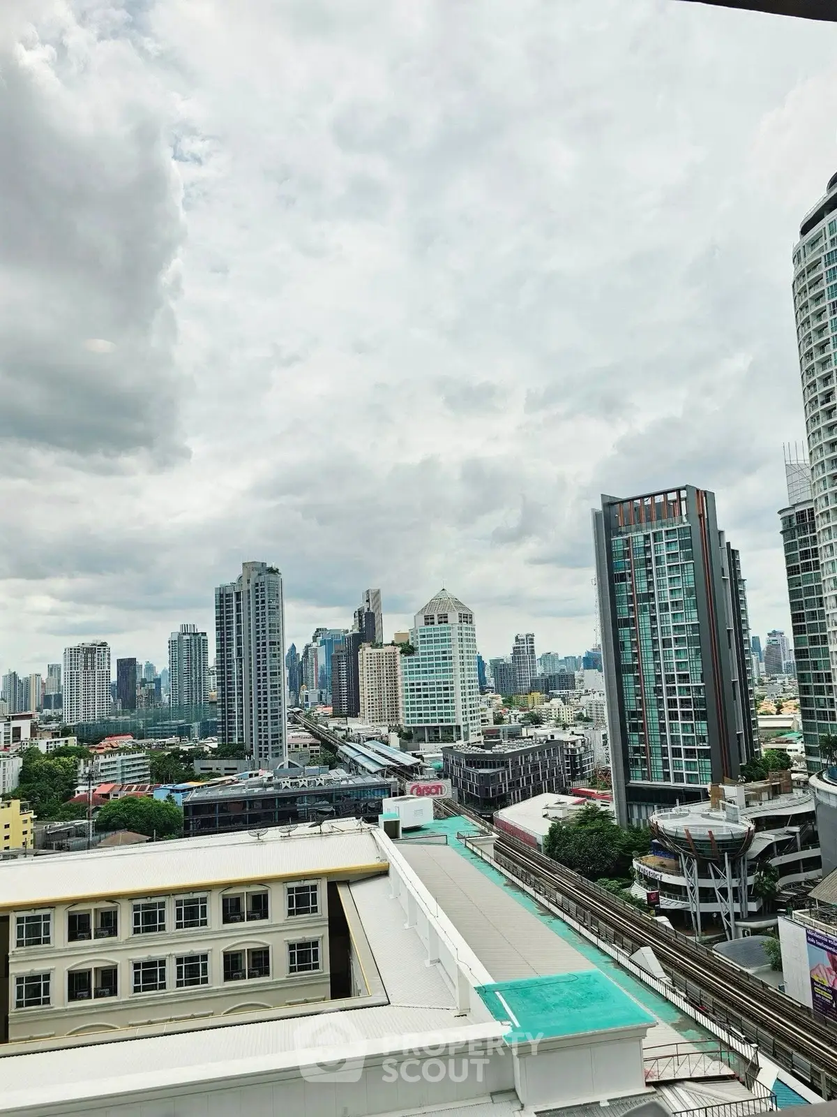 Stunning cityscape view from a high-rise building showcasing urban skyline and transportation infrastructure.