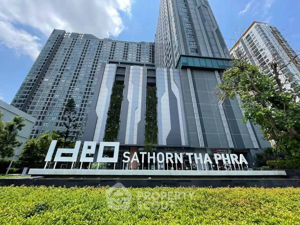 Modern high-rise condominium exterior with lush greenery at Ideo Sathorn Tha Phra.