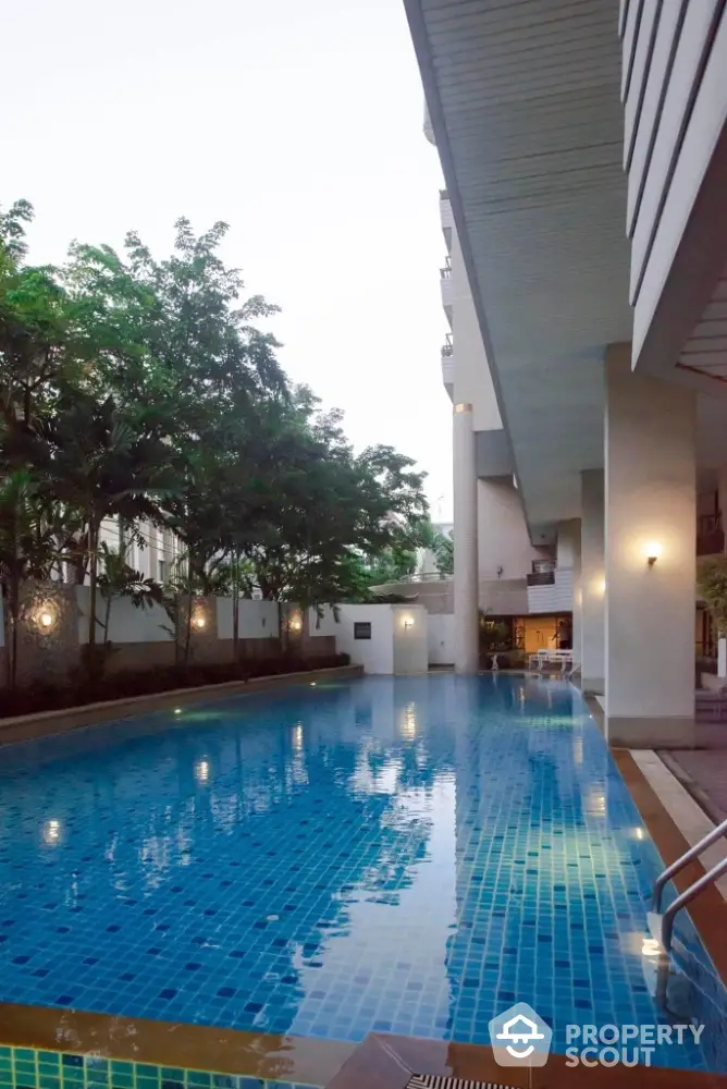 Luxurious outdoor swimming pool with modern design and ambient lighting in a serene residential setting.