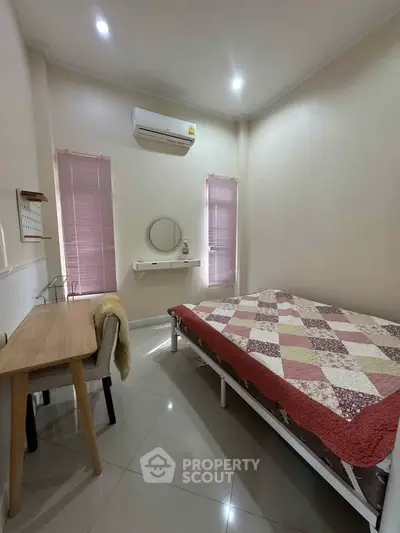 Cozy bedroom with modern decor, featuring a comfortable bed, desk, and air conditioning.