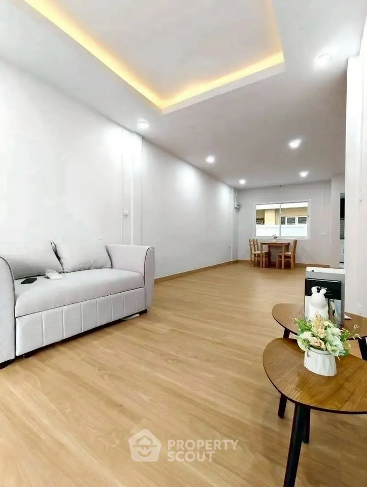 Spacious modern living room with elegant wooden flooring and cozy seating area.