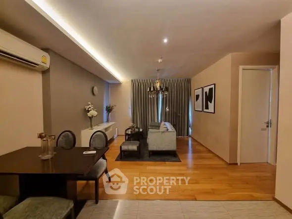 Elegant living room with modern decor and wooden flooring, featuring a cozy seating area and stylish dining space.