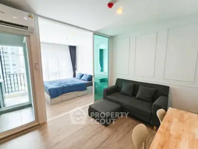 Modern apartment with open living room and bedroom, featuring a balcony view.