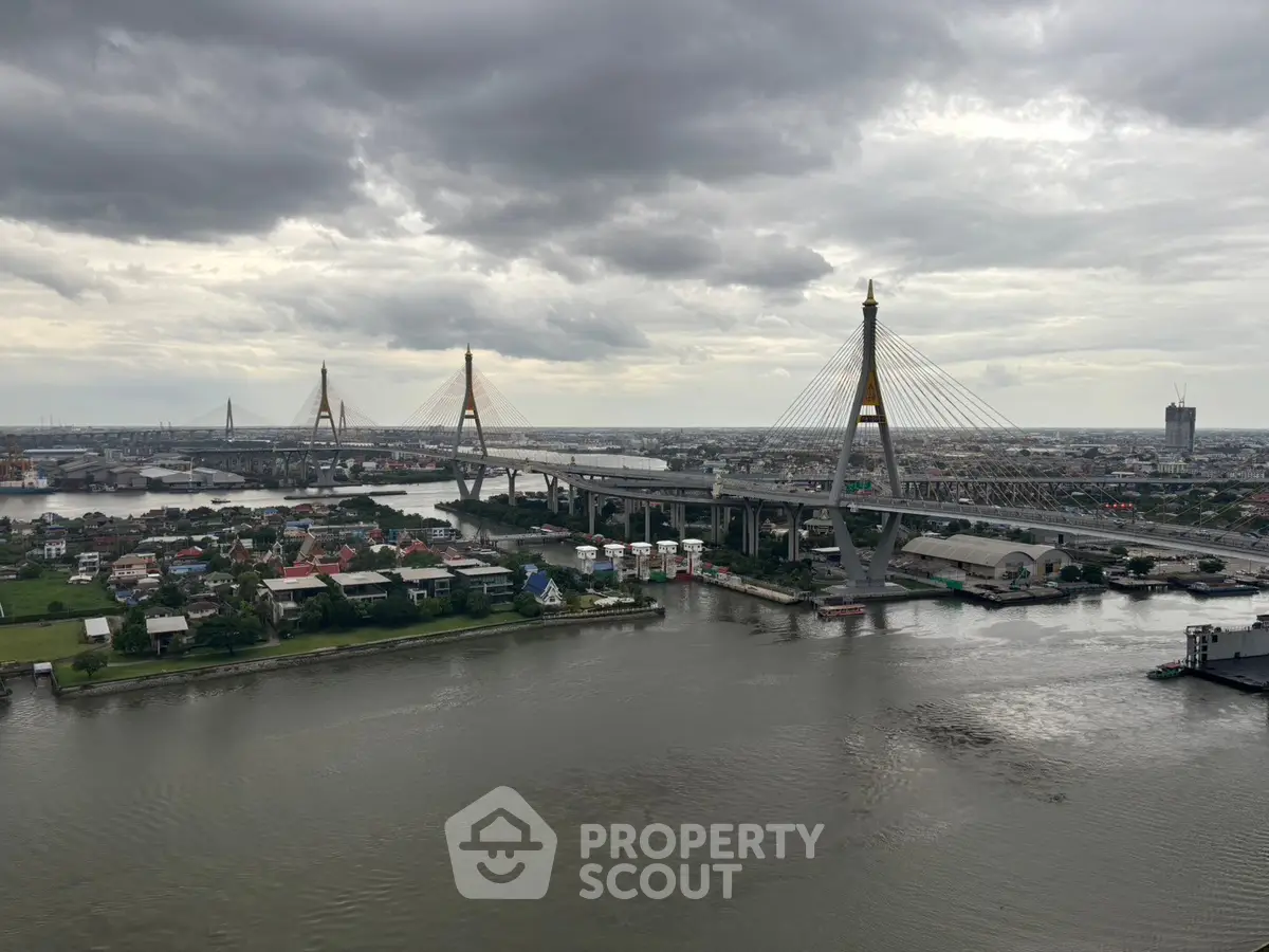 Stunning aerial view of a cityscape with a prominent bridge over a river, showcasing urban development.