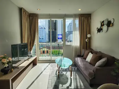 Modern living room with city view, stylish decor, and natural light