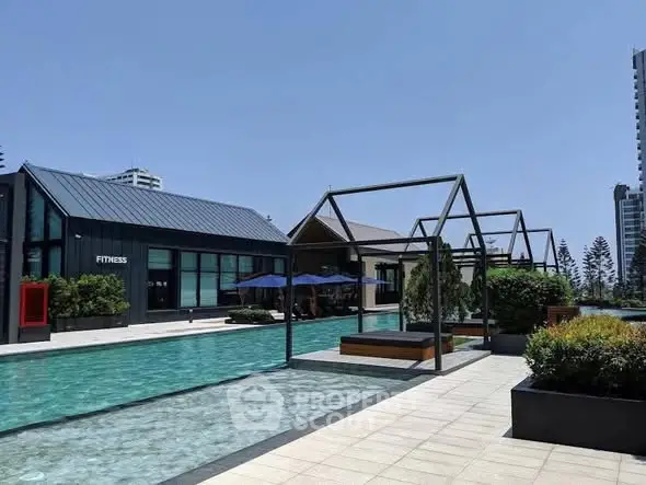 Luxurious outdoor pool area with modern architecture and fitness center in a high-rise residential complex.