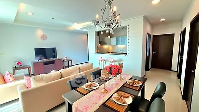 Spacious open-plan living and dining area with elegant chandelier and modern decor.