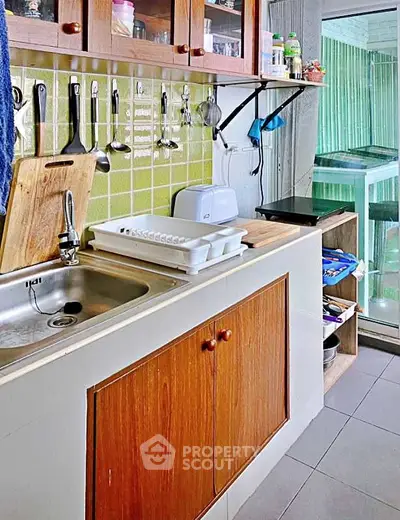 Charming kitchen with vintage wooden cabinets and green tile backsplash, featuring modern appliances and ample storage.