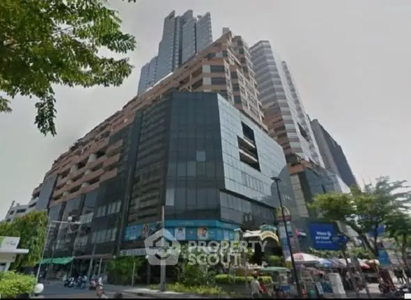 Stunning modern high-rise building with sleek glass facade and vibrant urban surroundings.