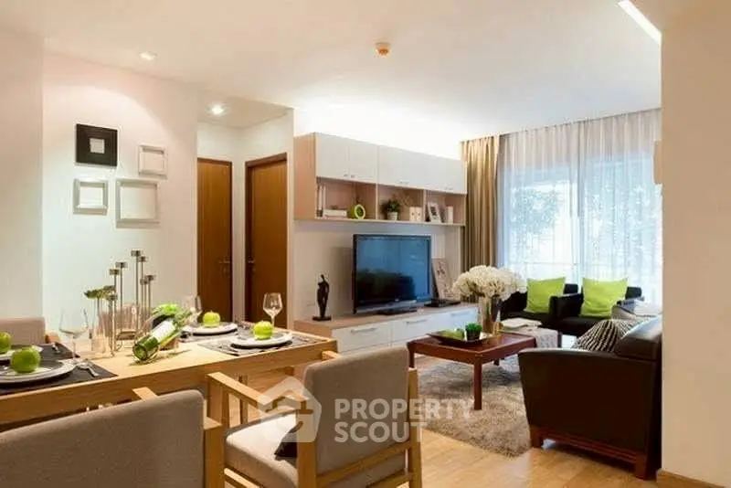 Modern living room with stylish decor and open dining area, featuring natural light and elegant furnishings.