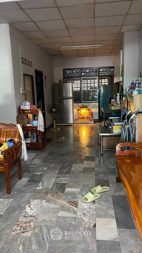 Spacious living area with marble flooring and modern appliances in a cozy home setting.