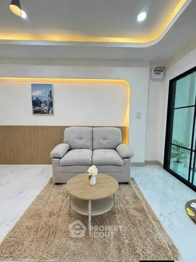 Modern living room with cozy sofa, stylish lighting, and elegant decor in a contemporary apartment.
