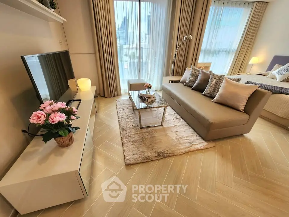 Modern living room with elegant decor and city view, featuring a cozy sofa and stylish TV setup.