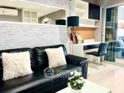 Modern living room with stylish black leather sofa and cozy workspace