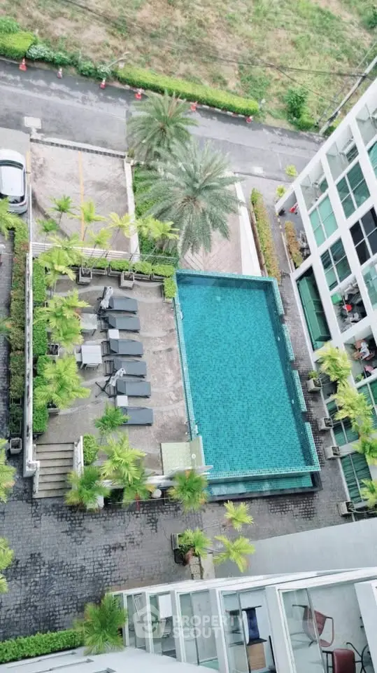 Stunning aerial view of modern apartment complex with pool and lush greenery, perfect for urban living.