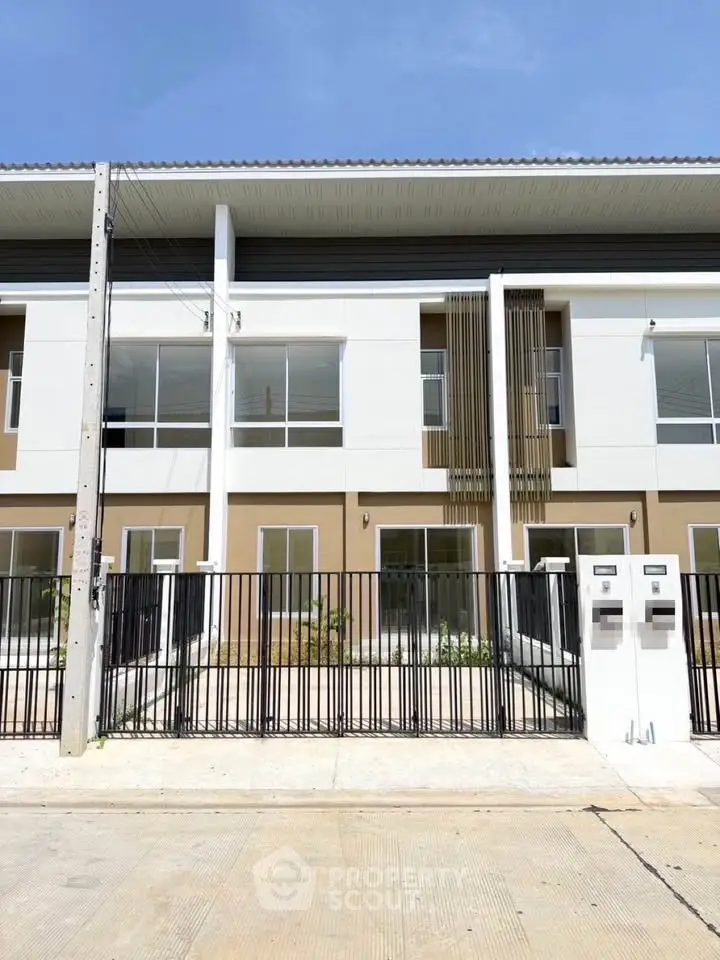 Modern townhouse exterior with sleek design and gated entrance, perfect for urban living.