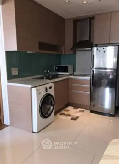Modern kitchen with sleek appliances and stylish cabinetry in a compact layout.