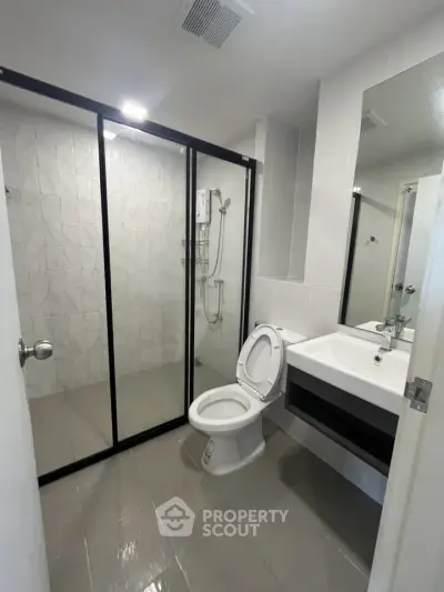 Modern bathroom with glass shower enclosure and sleek fixtures