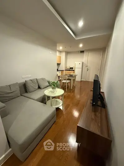 Modern living room with sleek furniture and wooden flooring in a cozy apartment.